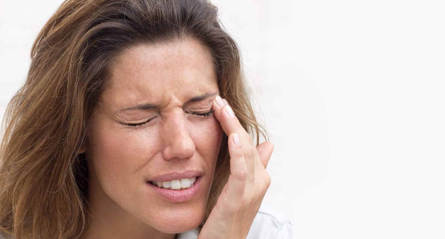 Woman looks uncomfortable and is rubbing dry eye