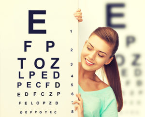 teen girl next to eye exam chart