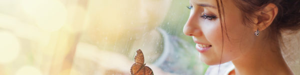 woman by window looking at a butterfly