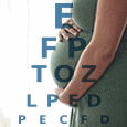 pregnant woman next to eye chart