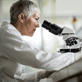 woman looking through a microscope
