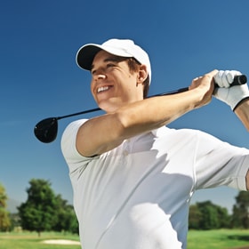 young man swinging a golf club