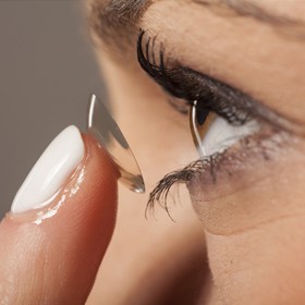woman putting in contact lens