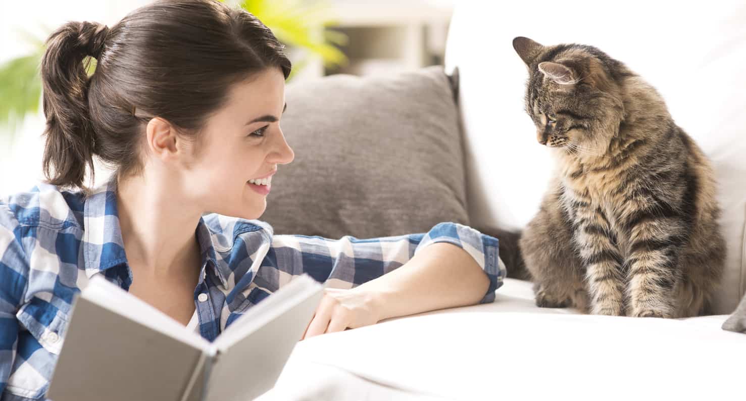 woman reading book to cat