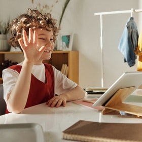 boy waving to computer
