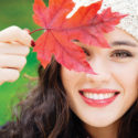 A woman holding a fall leaf