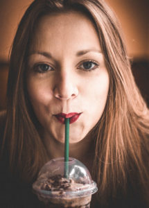 woman drinking blended coffee with straw