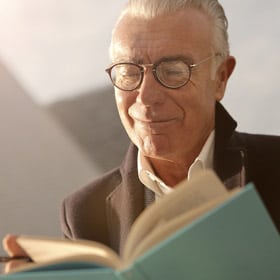 man with reading glasses and a book